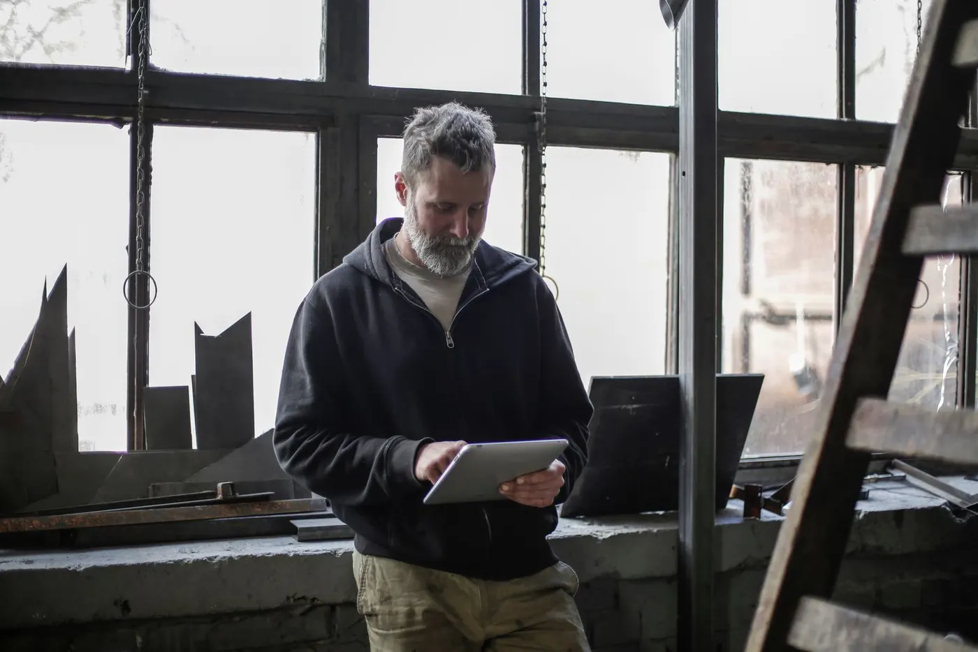 Un artisan consulte une tablette dans son atelier