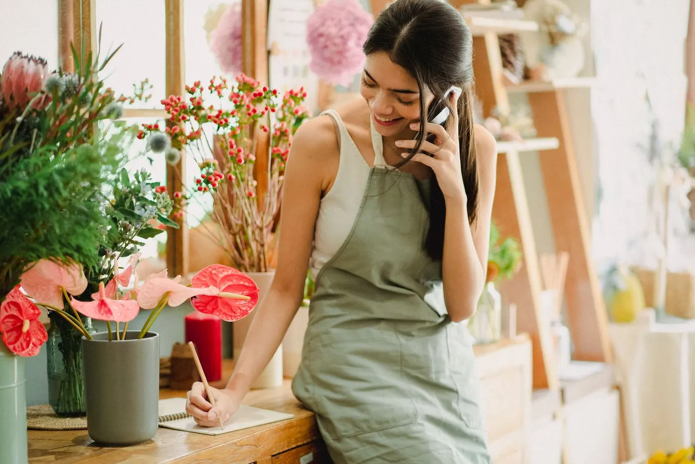 Une fleuriste consulte son téléphone dans sa boutique